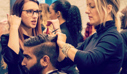 Two students work on a clients hair