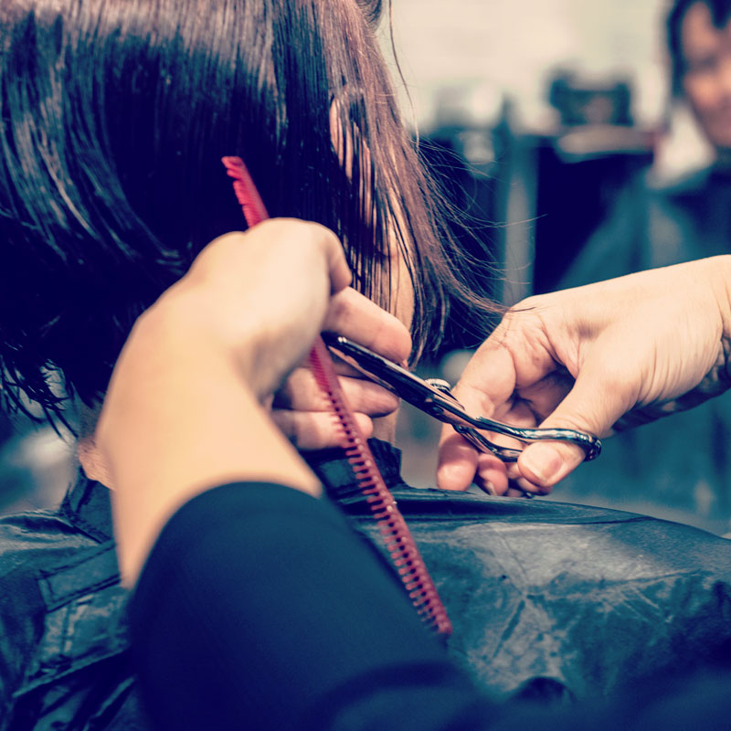 Student cutting a clients hair